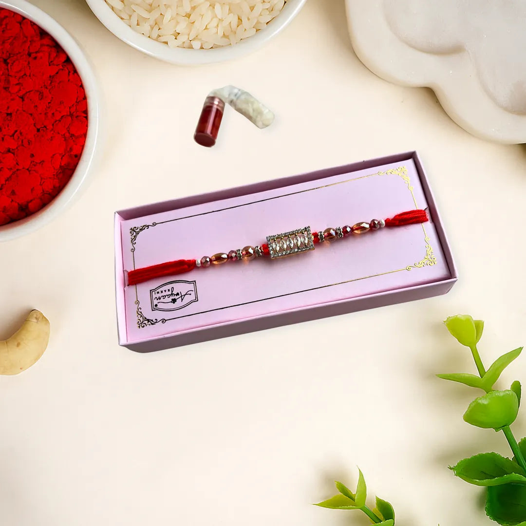 Rakhi in a box with red vermillion powder and rice on a light background